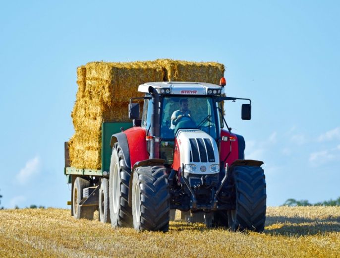 Traktor mit aufgeladenen Heuballen am Anhänger